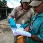 agentes do combate à dengue em pé realizando leitura de dados