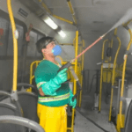 homem sanitizando um ônibus