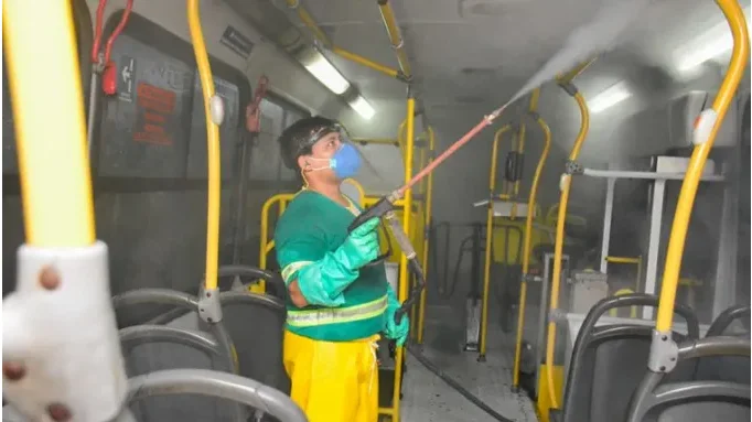 homem sanitizando um ônibus