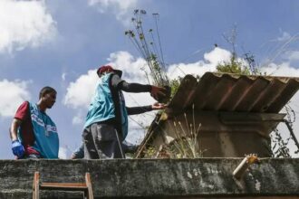 Agentes inspecionando caixa dágua em busca de focos de dengue